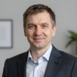 Портрет уверенного российского бизнесмена с дружелюбным взглядом на размытом нейтральном фоне в студии