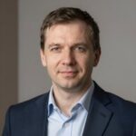 Профессиональный портрет уверенного российского бизнесмена на размытом нейтральном фоне для сайта бизнес-конференций